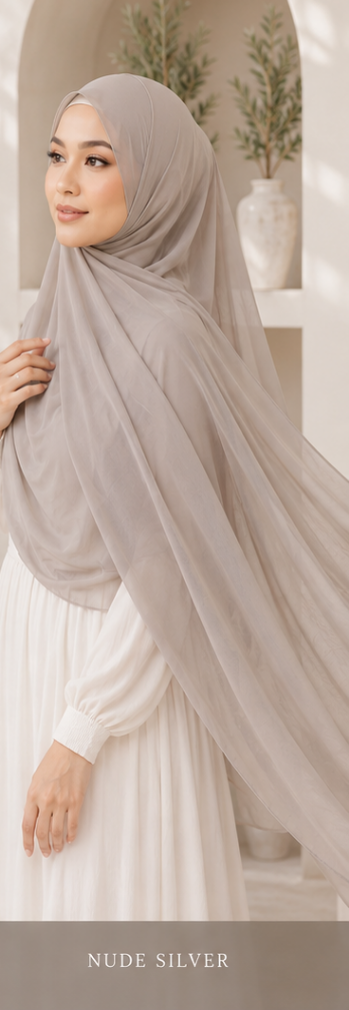 Woman wearing a Nude gray premium Malaysian georgette hijab and white dress in a neutral setting