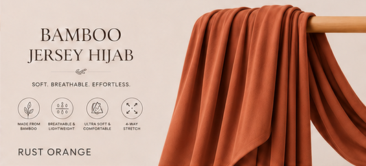 Rust Orange bamboo jersey hijab on a wooden rod with product features listed.