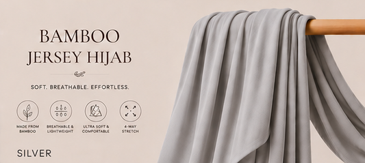 Silver Bamboo Jersey Islamic Hijab And Scarf fabric draped over a wooden rod against a beige background