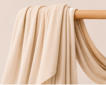 Cream-colored bamboo jersey hijab on a wooden rod with product features listed.