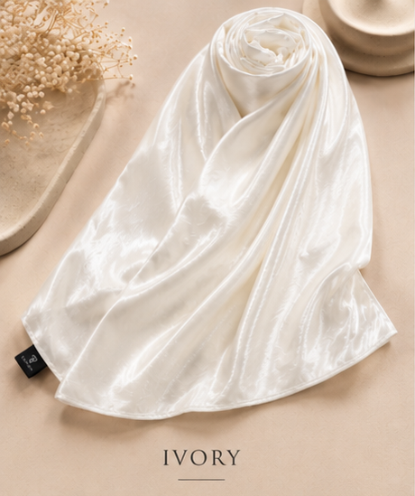 Ivory Bubble Satin Islamic Hijab scarf with a brand tag on a beige surface