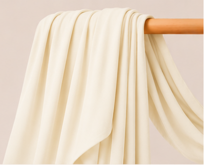 Ivory cream bamboo jersey hijab on a wooden rod with product features listed.