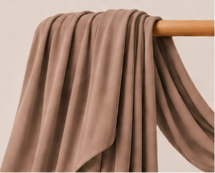 Nude brown bamboo jersey hijab on a wooden rod with product features listed.