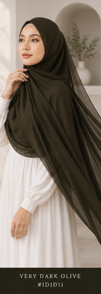 Woman wearing a dark olive premium Malaysian Georgette hijab with a white dress in a neutral setting